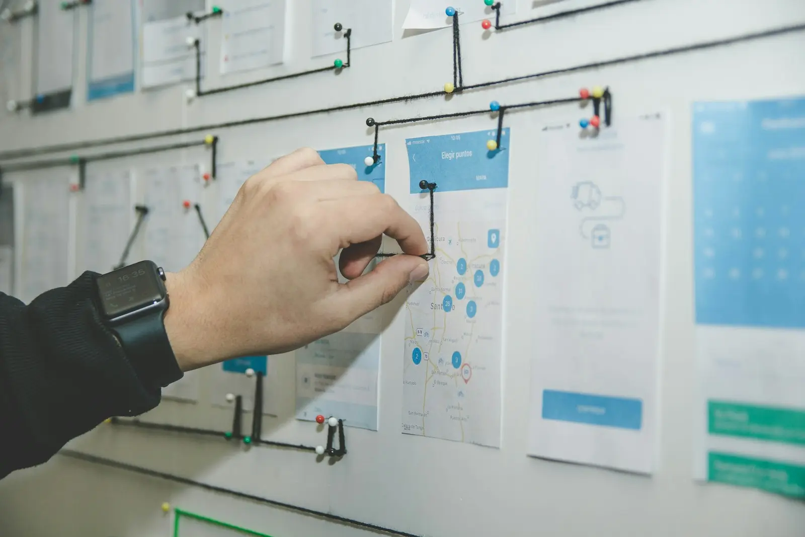 Social media and marketing layouts pinned to a wall for review